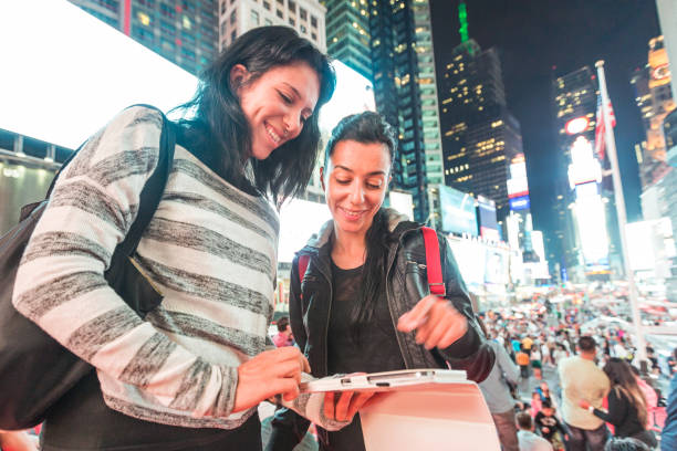 mädchen in new york bei nacht blick auf smartphone - digital tablet travel destinations new york state times square stock-fotos und bilder