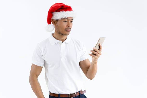 istock Serious Asian man wearing Santa hat and using smartphone 1061636122