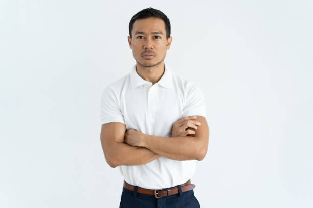 istock Serious Asian businessman in white tshirt looking at camera 1061636262