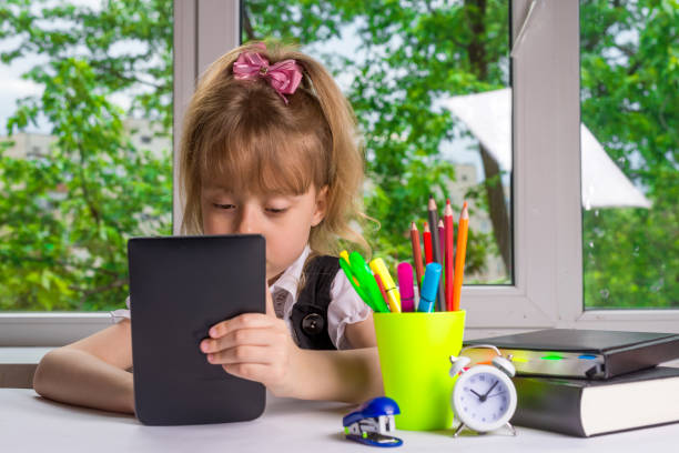 istock Schoolgirl doing homework on the tablet, free space. 1061636332