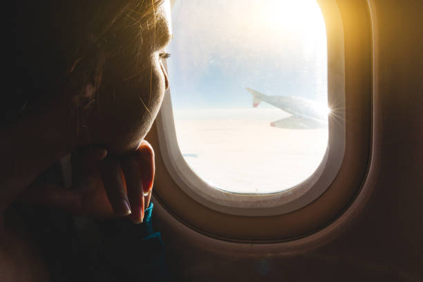 istock Woman looking out through airplane window 1061636370