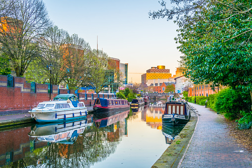 Puesta de sol vista de edificios de ladrillo junto a un canal de agua en el centro de Birmingham, Inglaterra photo