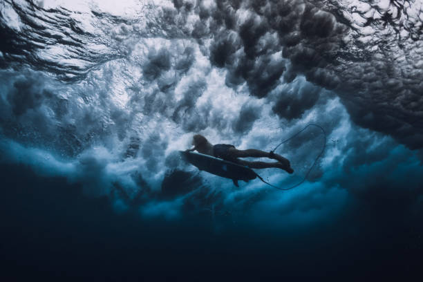 istock Surfer man with surfboard dive underwater. Surfer under ocean wave. 1061637980