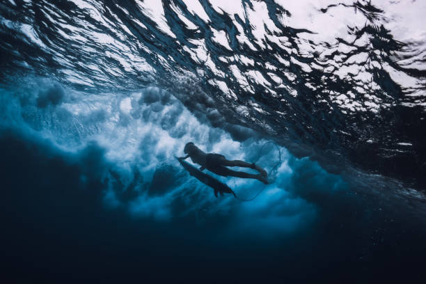 istock Professional surfer with surfboard dive underwater. Alone surfer and big ocean wave. 1061638028