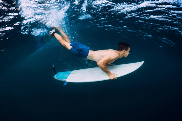 istock Professional surfer with surfboard dive underwater with ocean wave. 1061638096