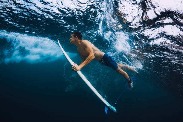 istock Surfer man with surfboard dive underwater with ocean wave. 1061638108