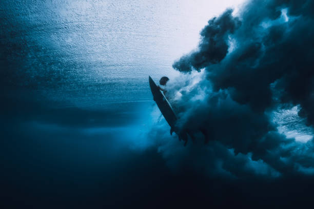 istock Surfer man with surfboard dive underwater with under ocean wave. 1061638204