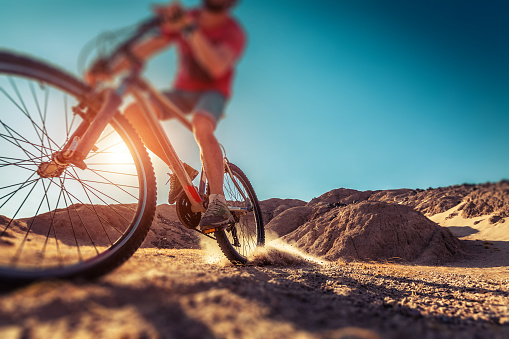 Man rides bicycle in the desert. Tilt shift effect applied