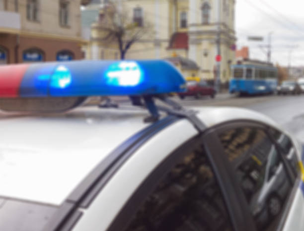 luci lampeggianti sul tetto di un'auto di pattuglia della polizia sullo sfondo di una strada irriconoscibile. immagine sfocata astratta. - late afternoon flash foto e immagini stock