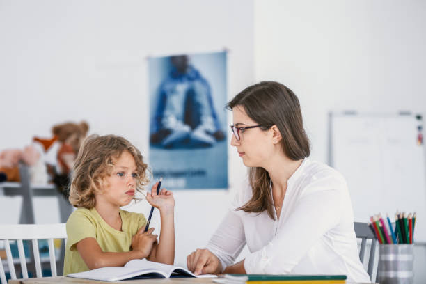 a young female tutor having a lesson with an absentminded child with concentration issues. - behavioral problems imagens e fotografias de stock