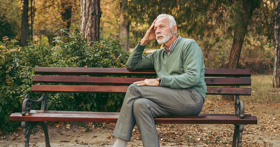 Senior man sitting on bench in the park