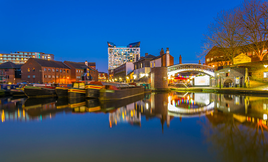 The cube behind brick buildings alongside a water channel in the central Birmingham, England