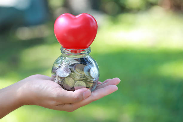 istock human hand saving money on red heart 1061642804