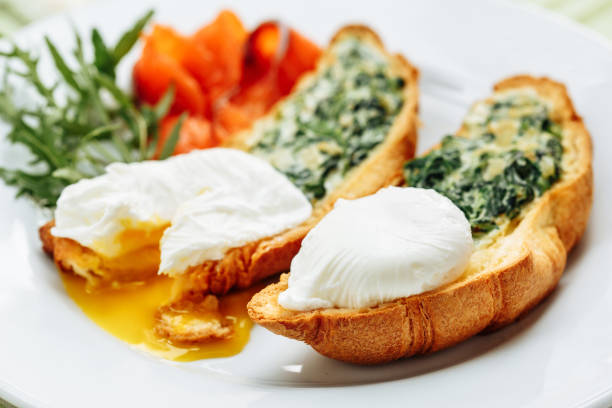ルッコラ添え全粒小麦のトーストしたクロワッサンにポーチドエッグ、スモーク サーモン。テーブル配置側拡大コピー スペース - sandwich breakfast boiled egg close up ストックフォトと画像