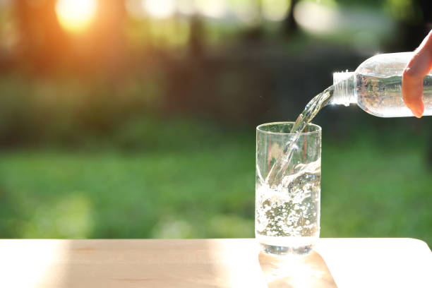 istock drink water pouring into empty glass with natural green background 1061643040