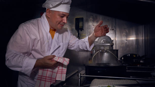 istock Professional chef cook in a white apron and cooks hat prepairing delicious meal on a kitchen. 1061645508
