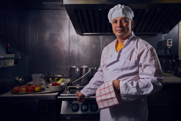 istock Professional chef cook in a white apron and cooks hat prepairing delicious meal on a kitchen. 1061645548