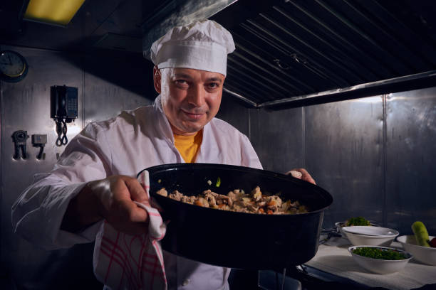 istock Professional chef cook in a white apron and cooks hat prepairing delicious meal on a kitchen. 1061645552