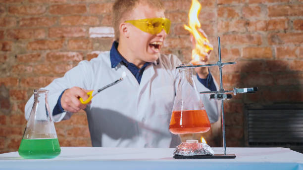 Funny picture with a male scientist conducts an experiment and his hand lights up. Chemist explorer accidentally sets fire to his hand and screams in fright. Security breach concept