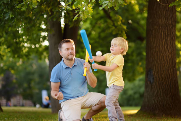 istock Father and his son playing baseball in park. 1061649292