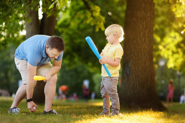 istock Father and his son playing baseball in park. 1061649300