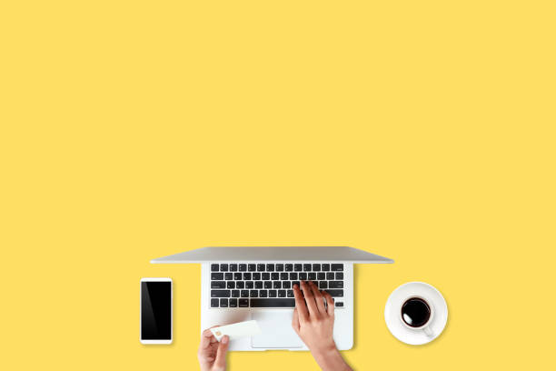 istock technology working table with woman hands on laptop computer, credit card, coffee cup and cell phone on yellow background (or shopping and payment online concept) 1061649858