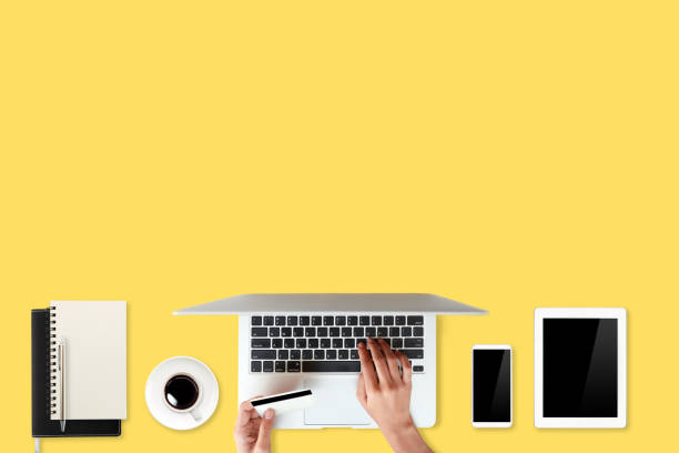 istock technology working table with woman hands on laptop computer, credit card, coffee cup and cell phone on yellow background (or shopping and payment online concept) 1061650152