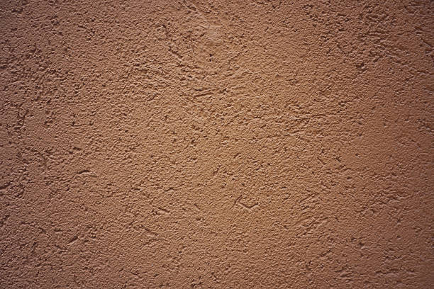istock Grunge plaster cement concrete wall texture with brown color paint with scratches 1061650874