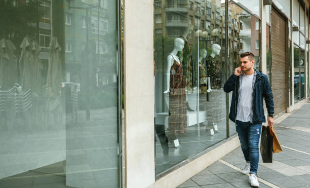 istock Man with shopping bags in front clothing store 1061651134