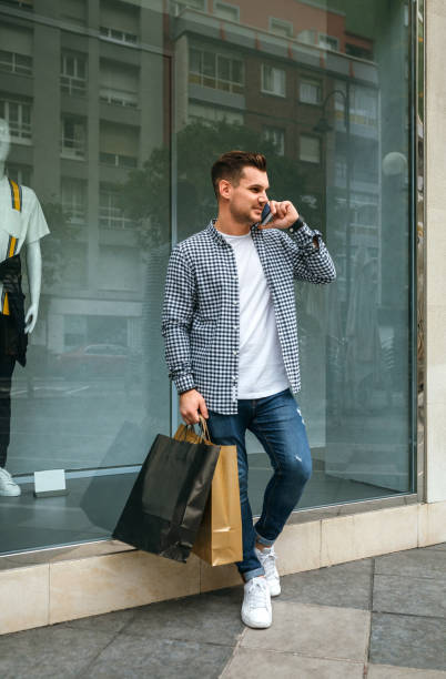 istock Young man with shopping bags and mobile 1061651192