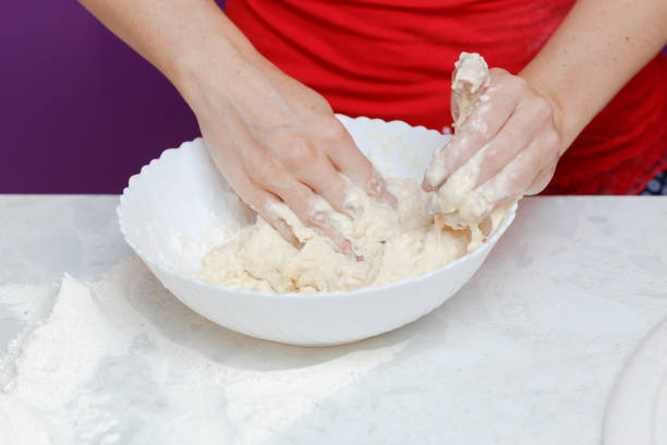 istock Making dough by female hands in bowl at home kitchen 1061654690