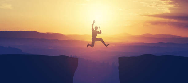 istock Man jumping above the cliff in the mountains. 1061655986
