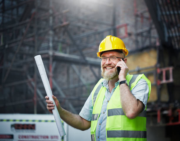 istock Male  building professional using phone on construction site smiles 1061657498