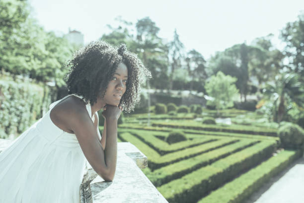 istock Pensive young black woman leaning on stone railing in park 1061658816