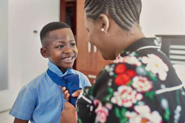 istock Mother adjusting necktie for smiling son at home 1061660824