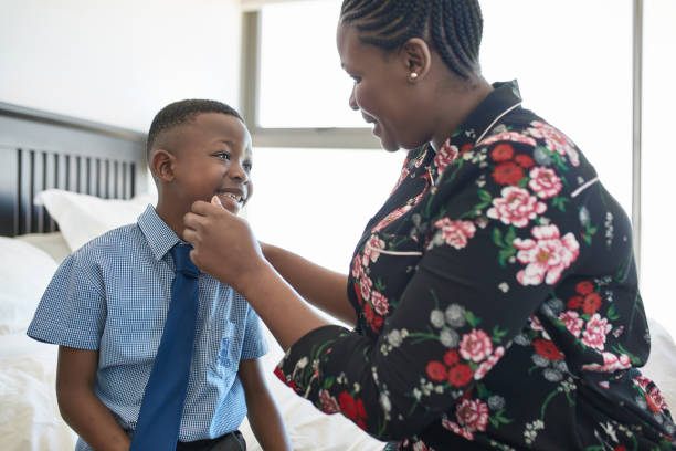 istock Happy mother looking at schoolboy sitting on bed 1061661008