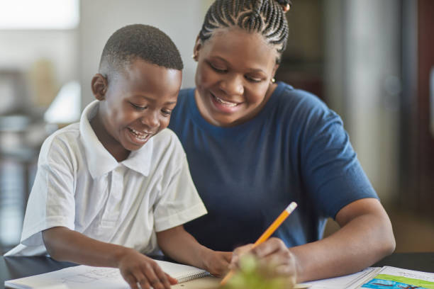 istock Smiling mother assisting son in doing homework 1061661260
