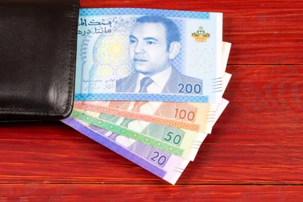 Moroccan money in the black wallet on a wooden background