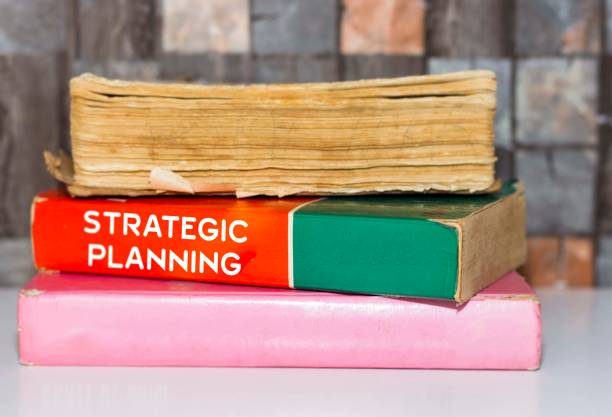 istock Strategic Planning - Business Book Title on wooden white table 1061668514