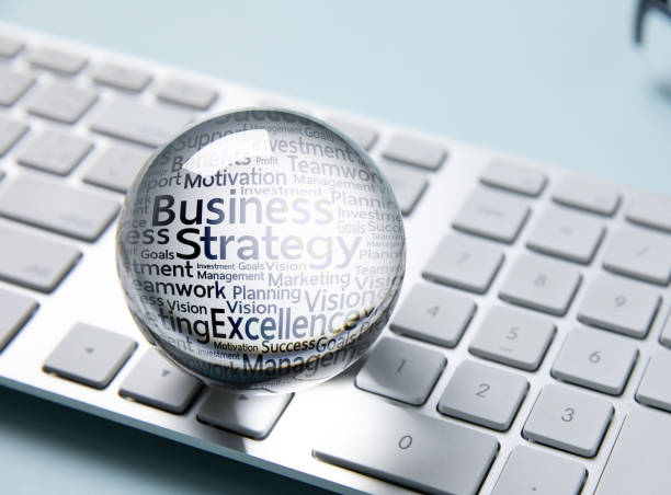 business icon in crystal ball on white computer keyboard