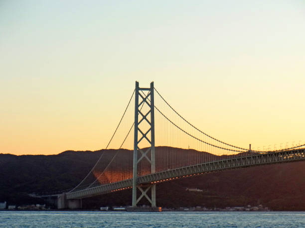 sonne untergeht akashi-kaikyo-brücke - kobe bridge japan suspension bridge stock-fotos und bilder