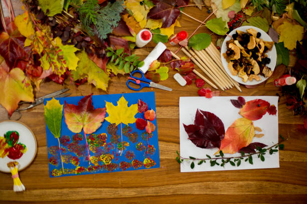 istock Children, applying leaves using glue, scissors, and paint, while doing arts and crafts in school 1061676928
