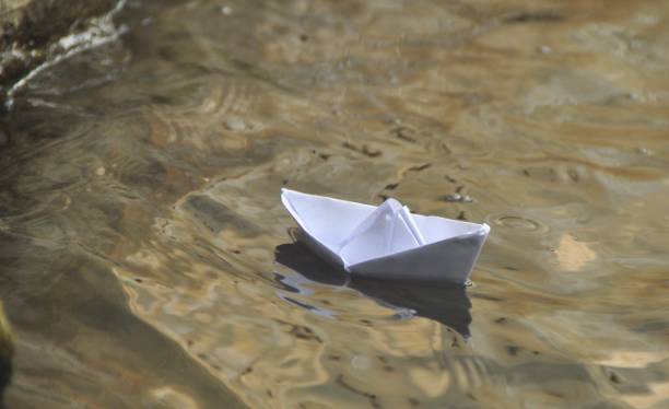 istock Paper boat in water 1061677128