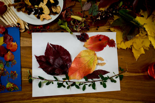 istock Children, applying leaves using glue, scissors, and paint, while doing arts and crafts in school 1061677164