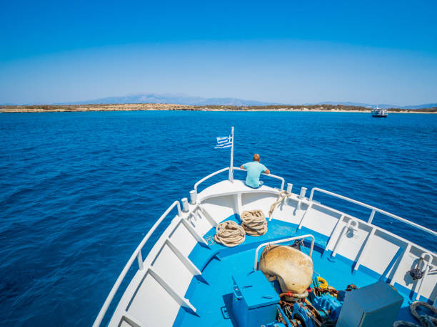 griechische flagge winken am bug eines bootes in richtung der insel chrissi oder in der karibik in griechenland segeln - chrissy stock-fotos und bilder