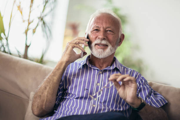 istock Senior man chatting on a mobile phone at home 1061693936