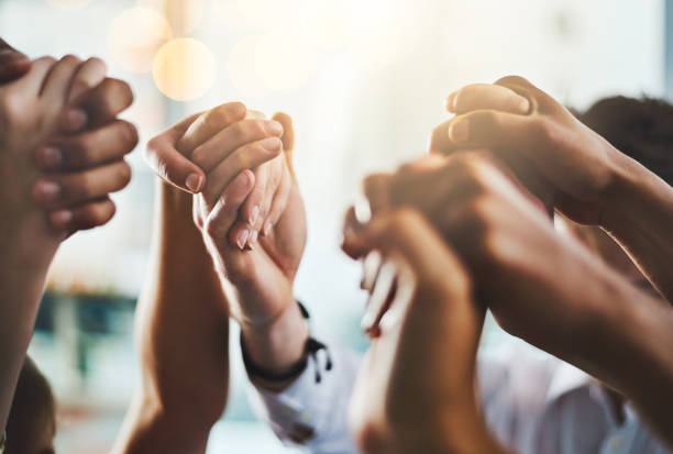 We need to encourage and uplift one another Closeup shot of a group of businesspeople holding hands together in solidarity hands clasped stock pictures, royalty-free photos & images