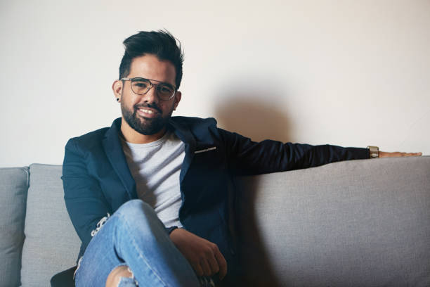 istock Young bearded man taking poising at home. Young handsome man looking at camera while standing in center of living room modern apartment. 1061695190