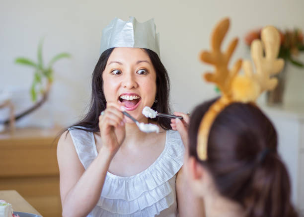 Mum and daughter having fun eating Pavlova at Christmas lunch Australian Christmas family celebrations and eating with children eating child cracker asia stock pictures, royalty-free photos & images