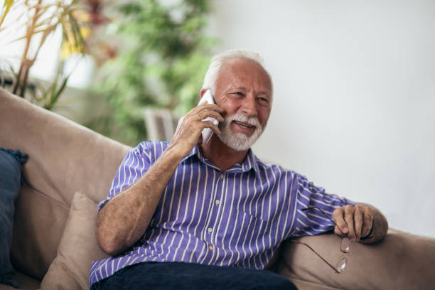 istock Senior man chatting on a mobile phone at home 1061696716